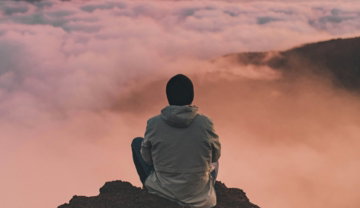 man sitting on cliff